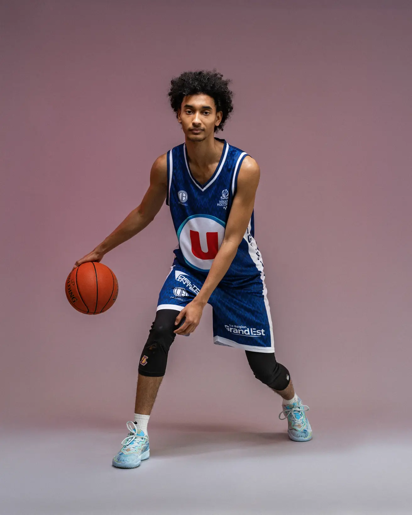 Basketball player dribbling in studio lighting