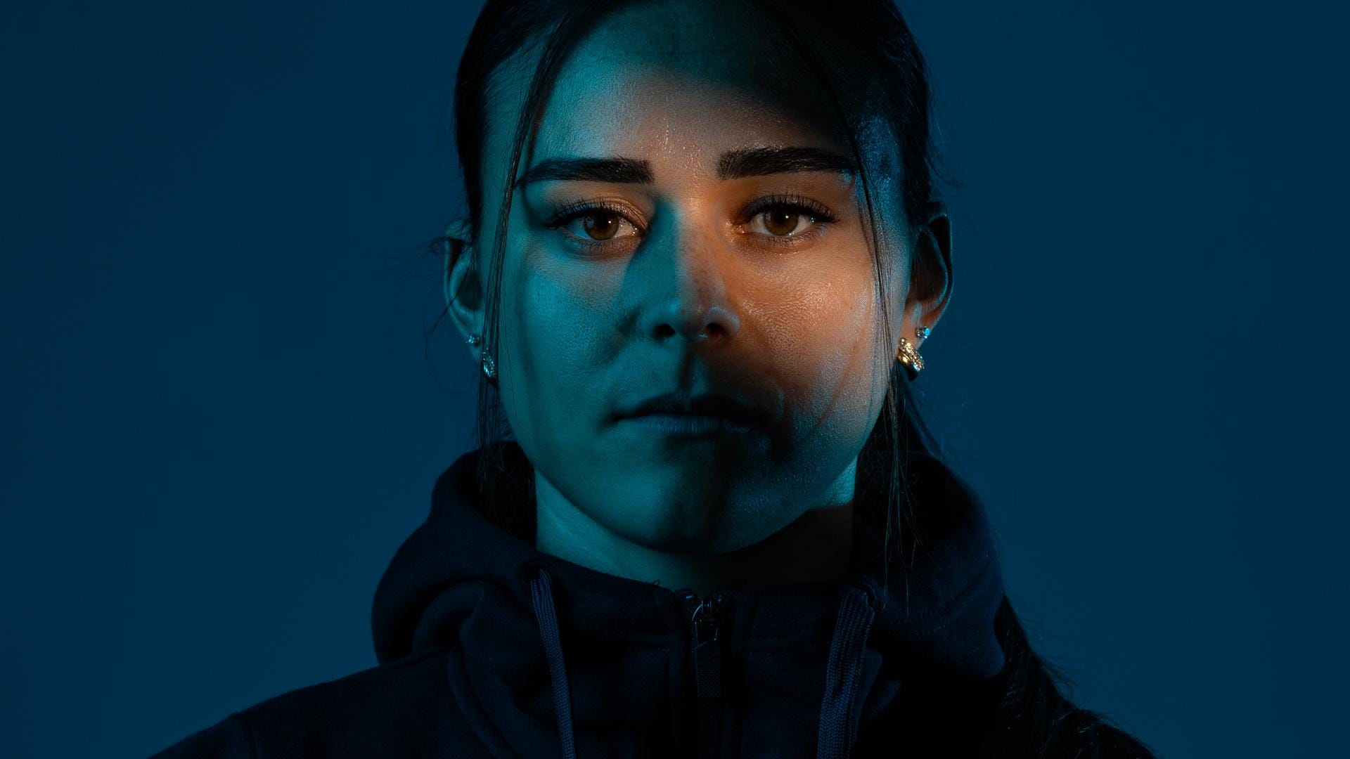 Athlete portrait in moody blue studio light